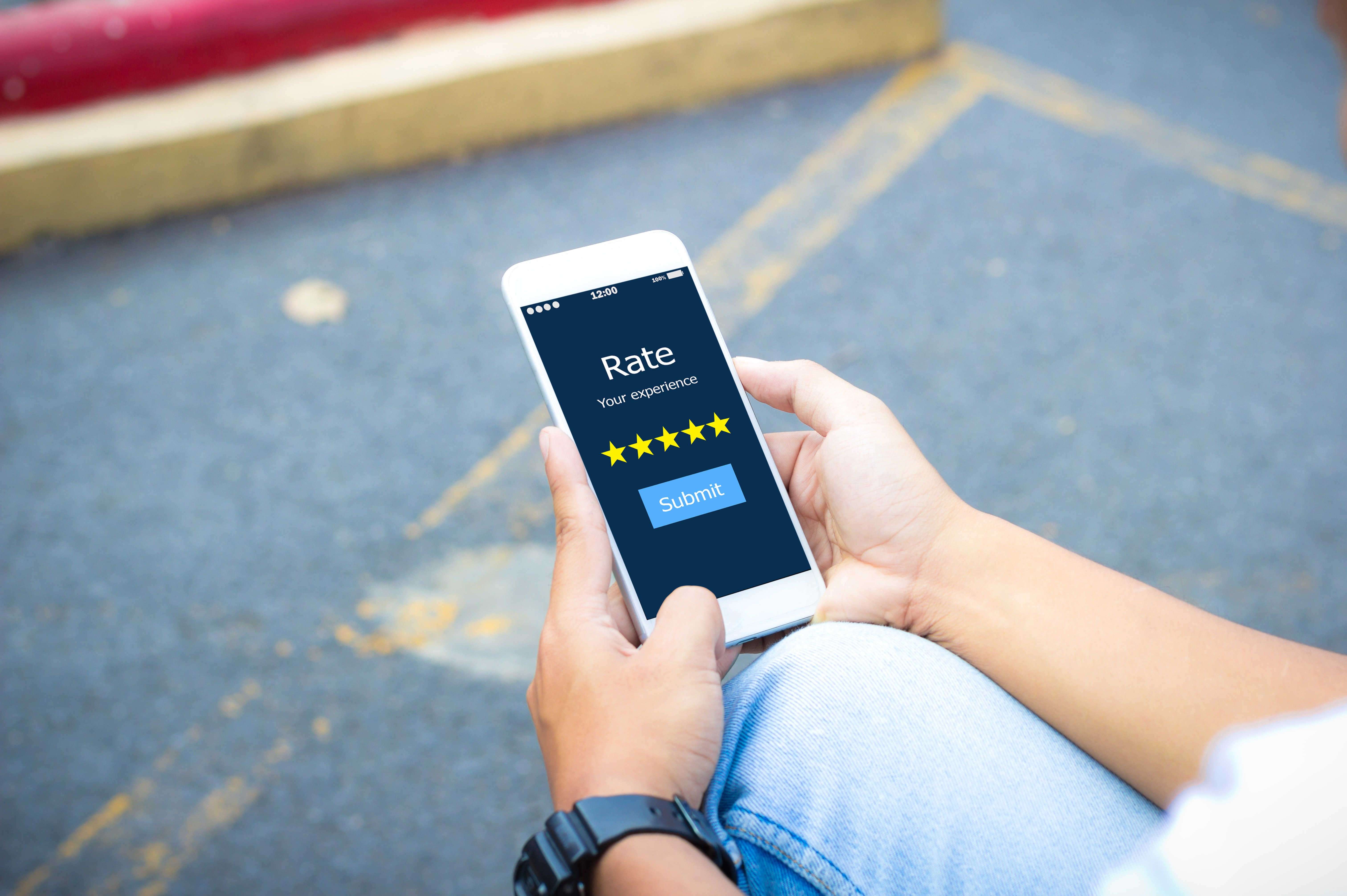 Driver rating their experience on a smartphone in a parking lot